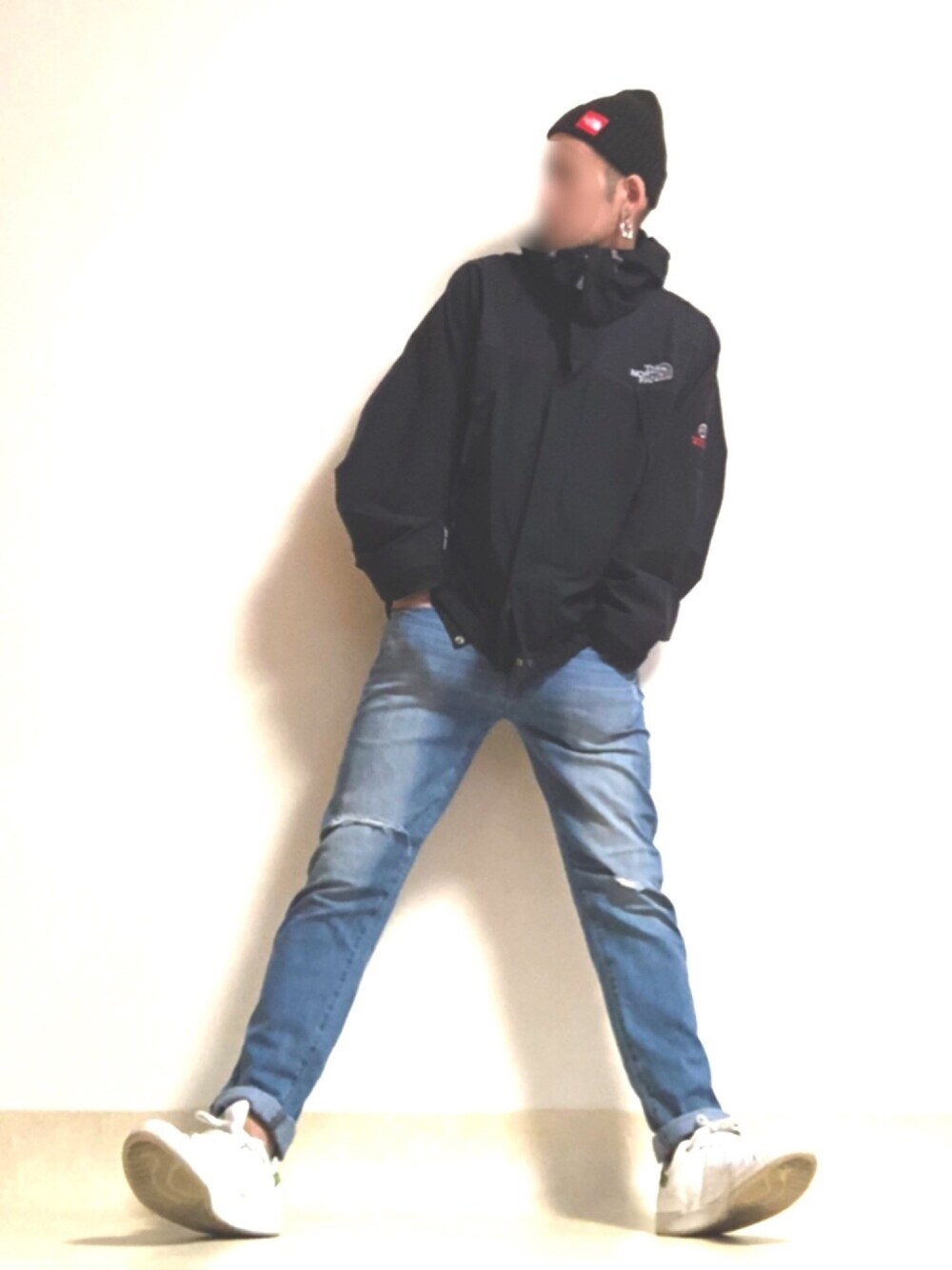 ホワイト系のスニーカー、ブルー系のデニムパンツ、ブラック系のマウンテンパーカーを着用したメンズの夏コーディネートの1枚目の写真