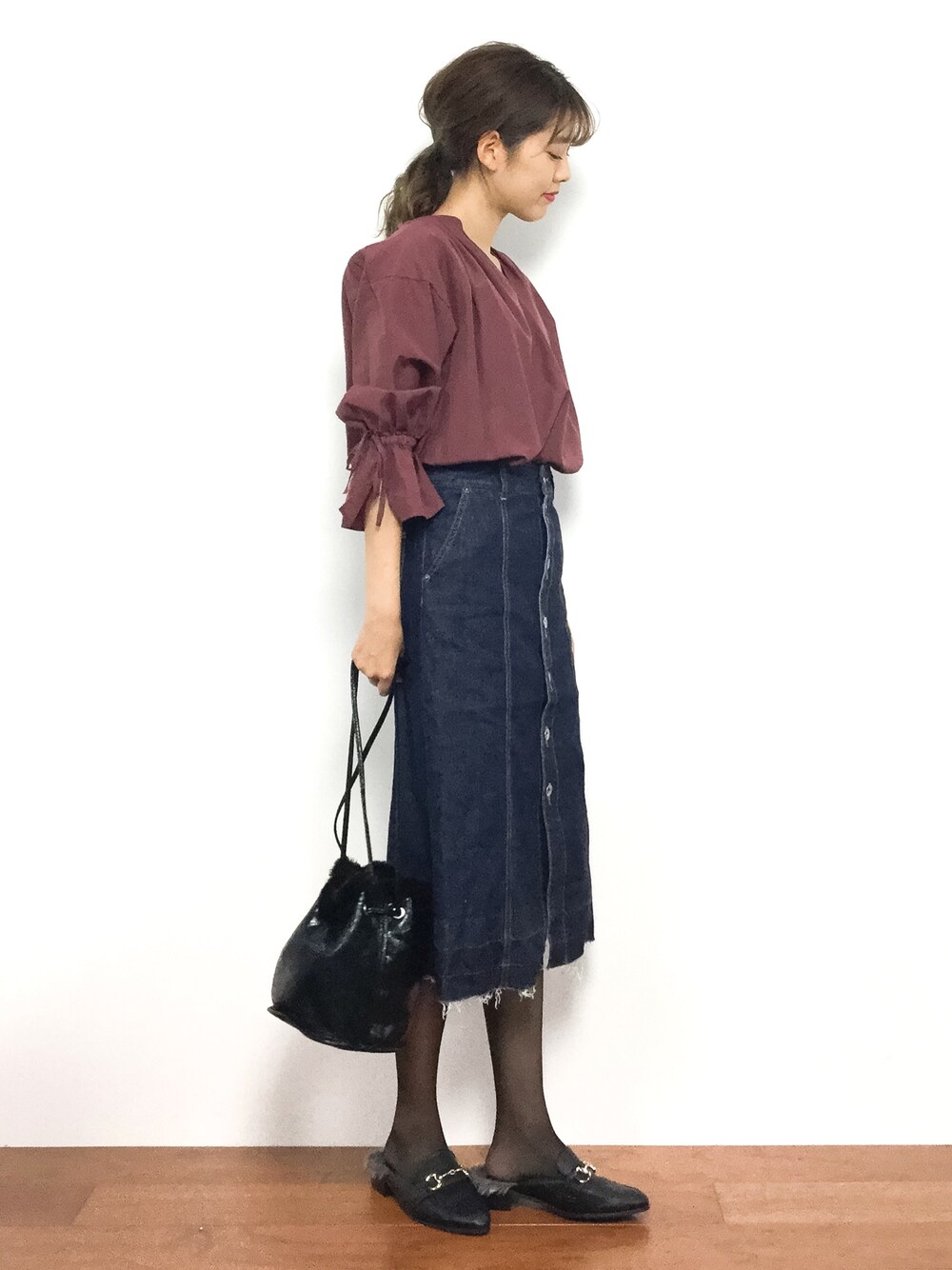 レッド系のシャツ/ブラウス、ブルー系のデニムスカート、ブラック系のハンドバッグを着用したレディースの秋コーディネートの1枚目の写真