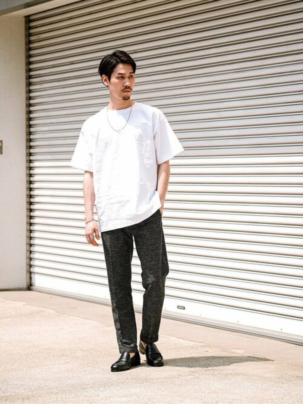 ホワイト系のTシャツ/カットソー、グレー系のその他パンツ、ブラック系のドレスシューズを着用したメンズの春コーディネートの1枚目の写真