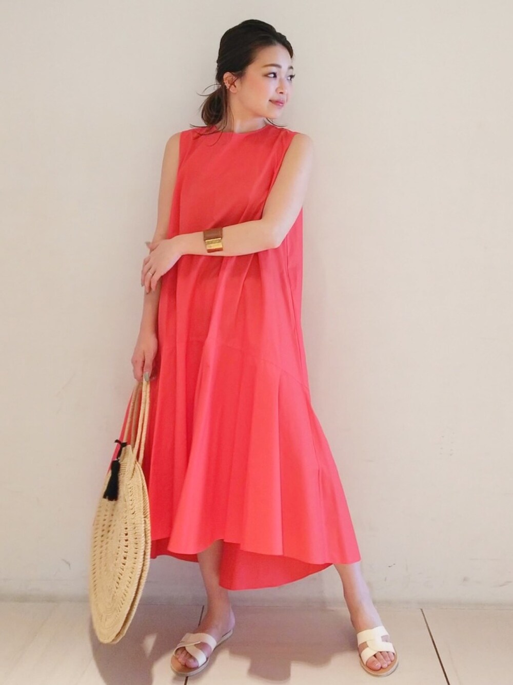 レッド系のワンピース、ベージュ系のかごバッグを着用したレディースの春コーディネートの1枚目の写真