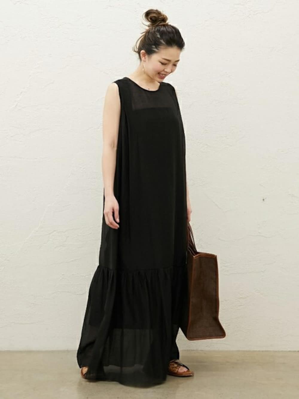 ブラック系のワンピースを着用したレディースの春コーディネートの1枚目の写真