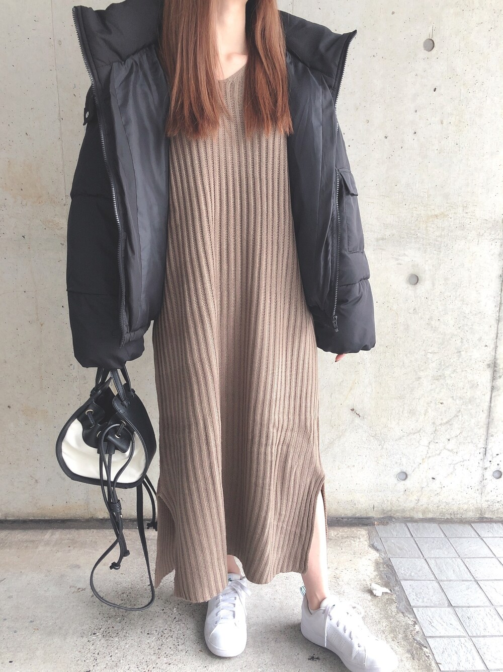 ブラウン系のワンピース、ブラック系のダウンジャケット/コート、ブラック系のハンドバッグを着用したレディースの冬コーディネートの1枚目の写真