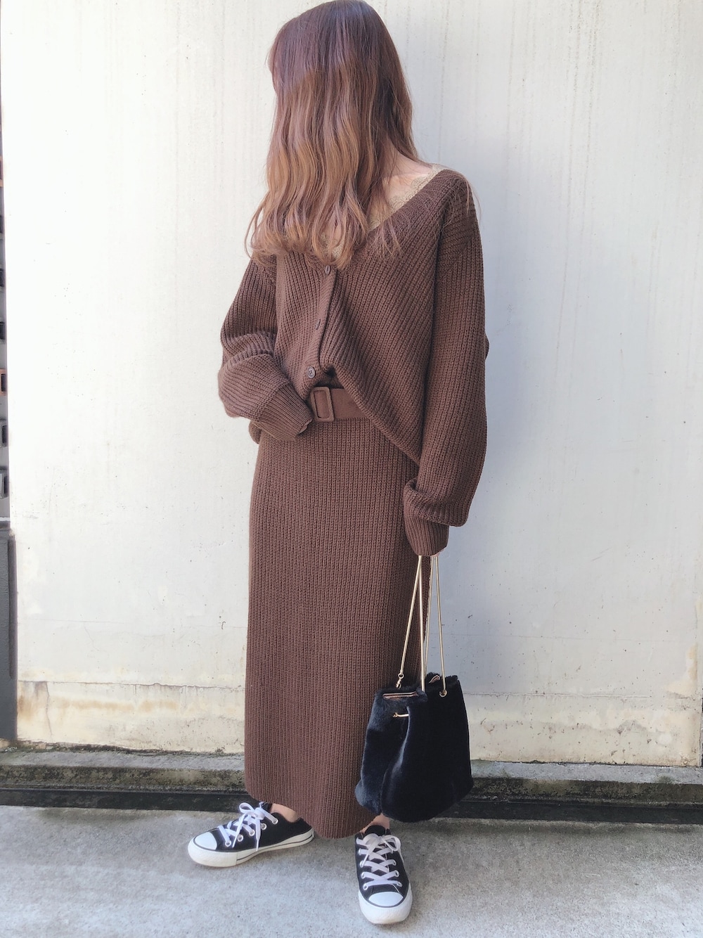 ブラウン系のセットアップ、ブラック系のハンドバッグ、ブラウン系のキャミソールを着用したレディースの冬コーディネートの1枚目の写真