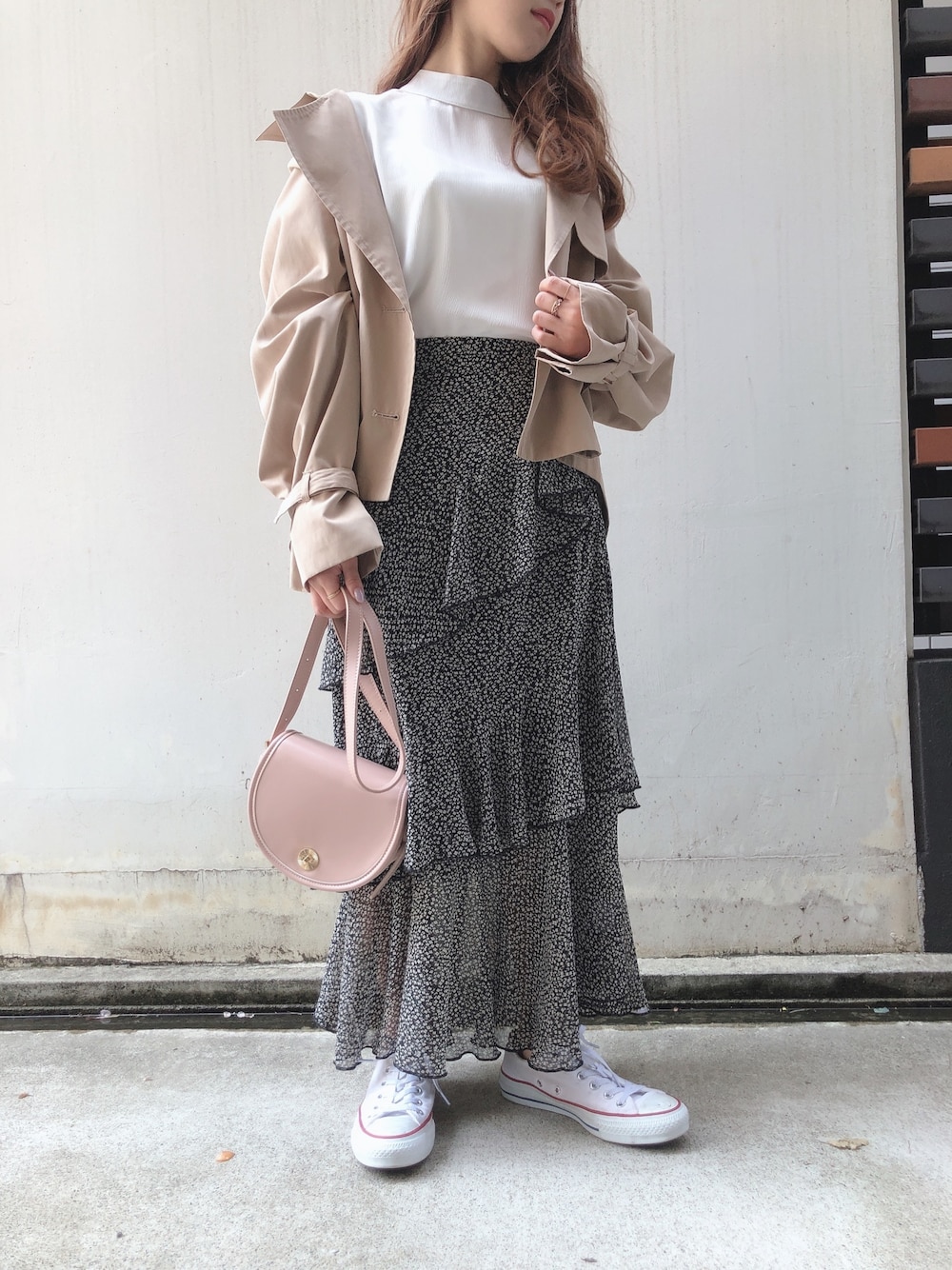 ブラック系のスカート、ホワイト系のシャツ/ブラウス、ベージュ系のトレンチコートを着用したレディースの春コーディネートの1枚目の写真