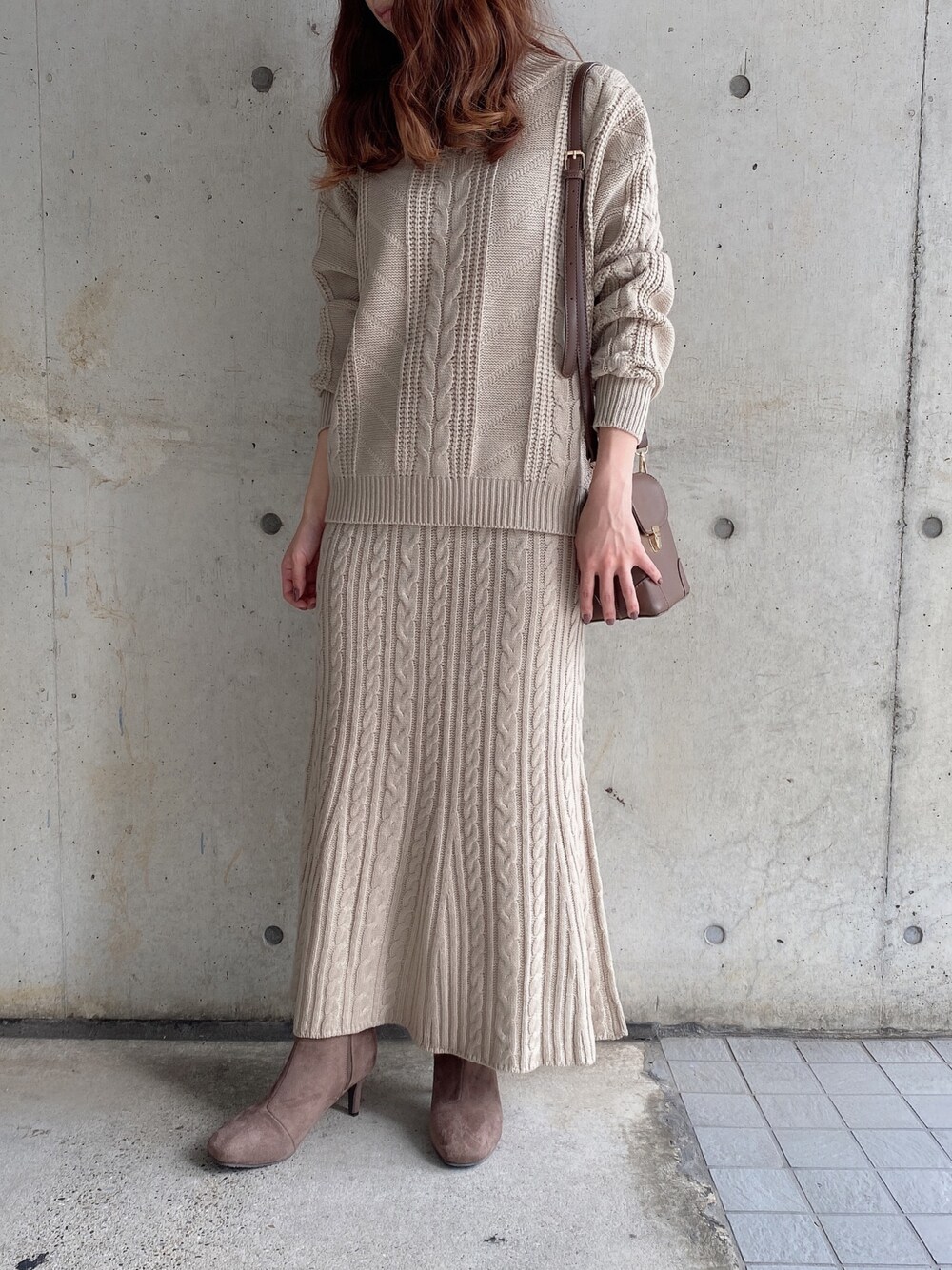 ベージュ系のセットアップ、ブラウン系のショルダーバッグを着用したレディースの秋コーディネートの1枚目の写真