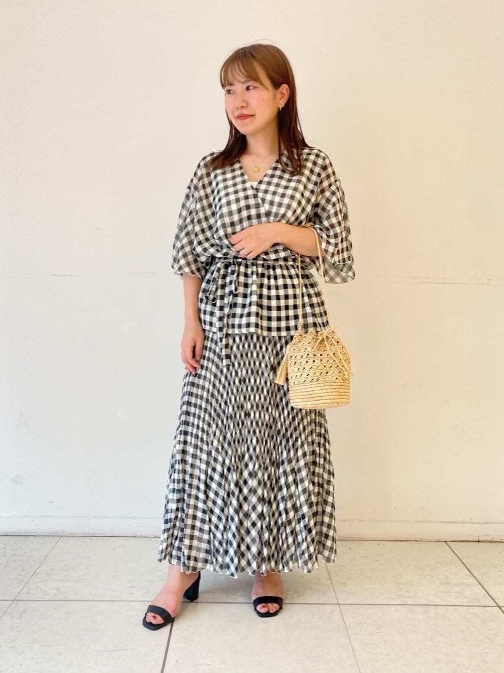 ホワイト系のショルダーバッグ、ブラック系のサンダル、ホワイト系のスカートを着用したレディースの春コーディネートの1枚目の写真