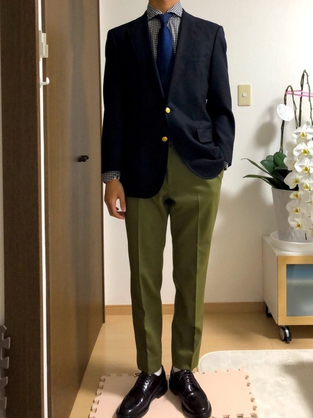 グリーン系のその他パンツ、レッド系のドレスシューズ、ブルー系のネクタイを着用したメンズの春コーディネートの1枚目の写真