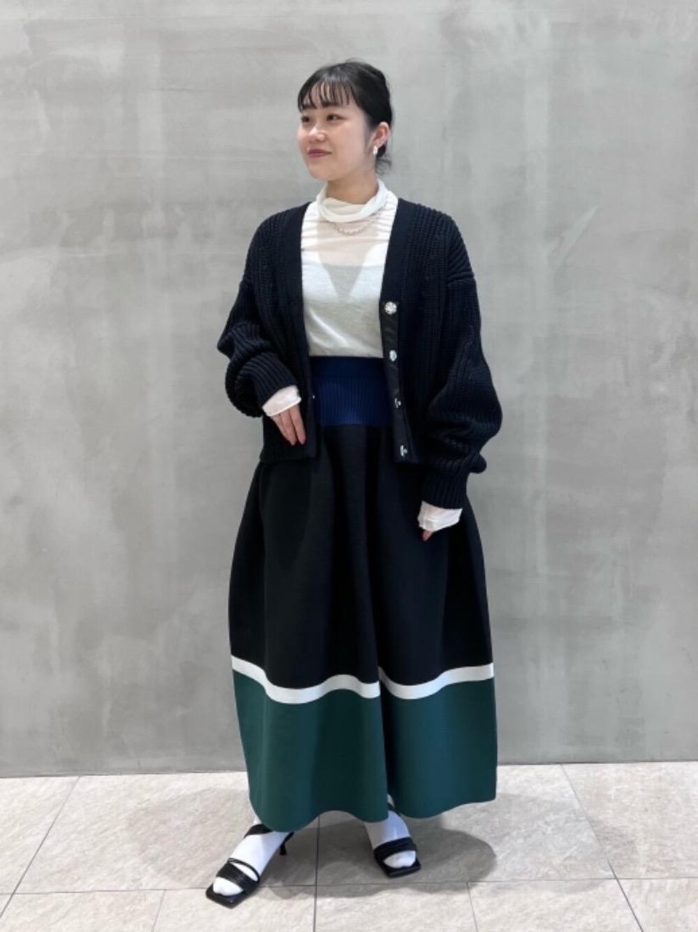 ホワイト系のTシャツ/カットソー、ブラック系のサンダル、ブラック系のカーディガン/ボレロを着用したレディースの冬コーディネートの1枚目の写真