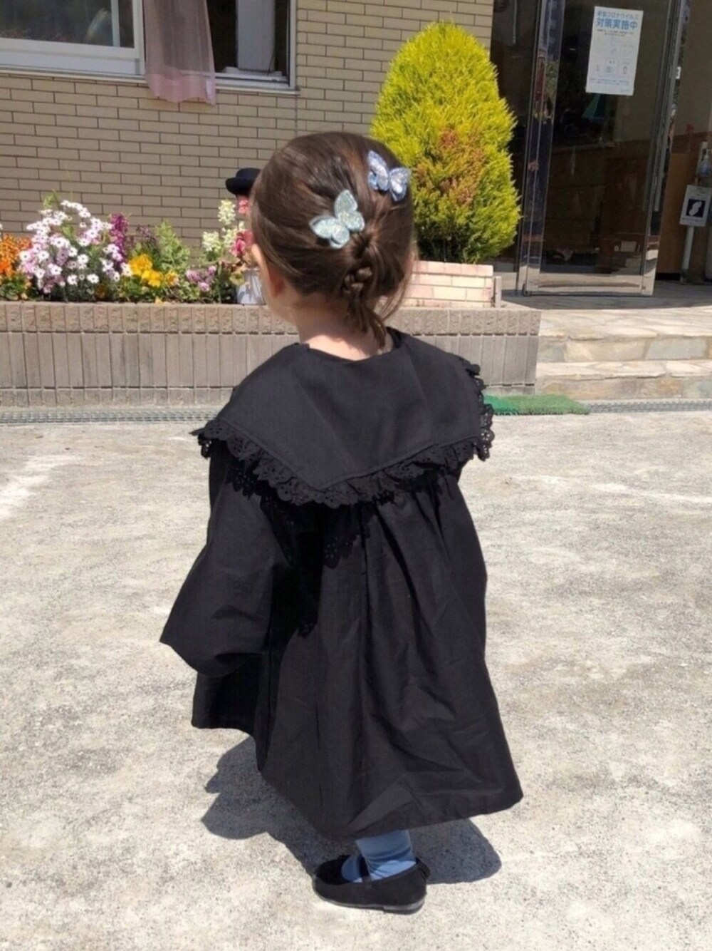 ブラック系のワンピース、ブラック系のバレエシューズ、グリーン系のバレッタ/ヘアクリップを着用したキッズの春コーディネートの1枚目の写真