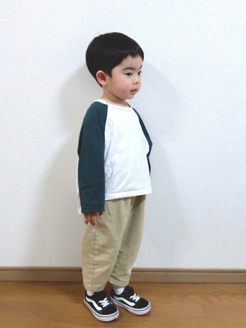 ホワイト系のTシャツ/カットソー、ベージュ系のチノパンツ、ブラック系のスニーカーを着用したキッズの春コーディネートの1枚目の写真