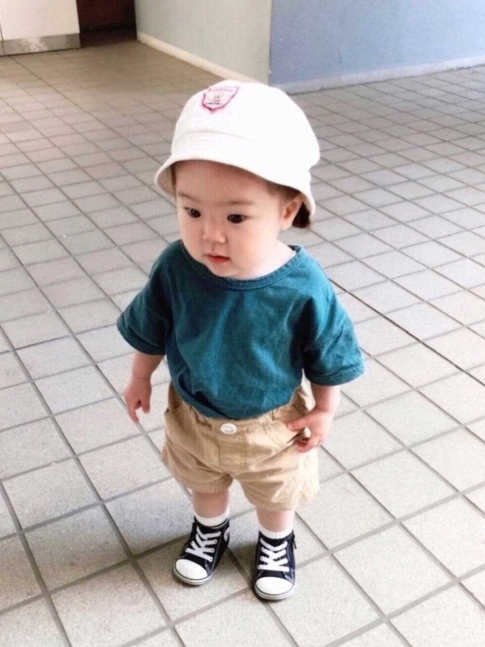 グリーン系のTシャツ/カットソー、ベージュ系のその他パンツ、ブラック系のスニーカーを着用したキッズの春コーディネートの1枚目の写真