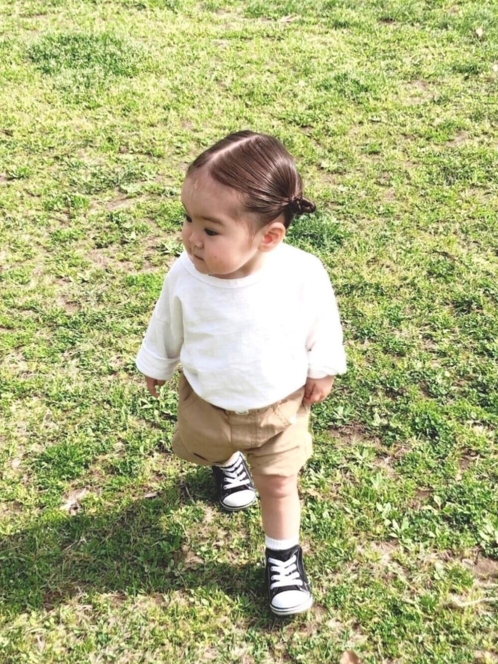 ベージュ系のその他パンツ、ブラック系のスニーカー、ホワイト系のTシャツ/カットソーを着用したキッズの春コーディネートの1枚目の写真