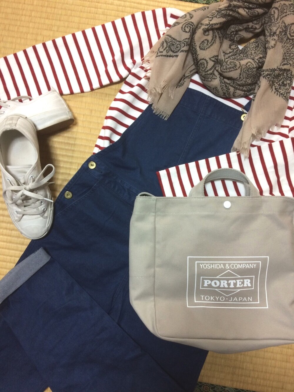 ホワイト系のスニーカー、ホワイト系のTシャツ/カットソー、ブルー系のサロペット/オーバーオールを着用したレディースの春コーディネートの1枚目の写真