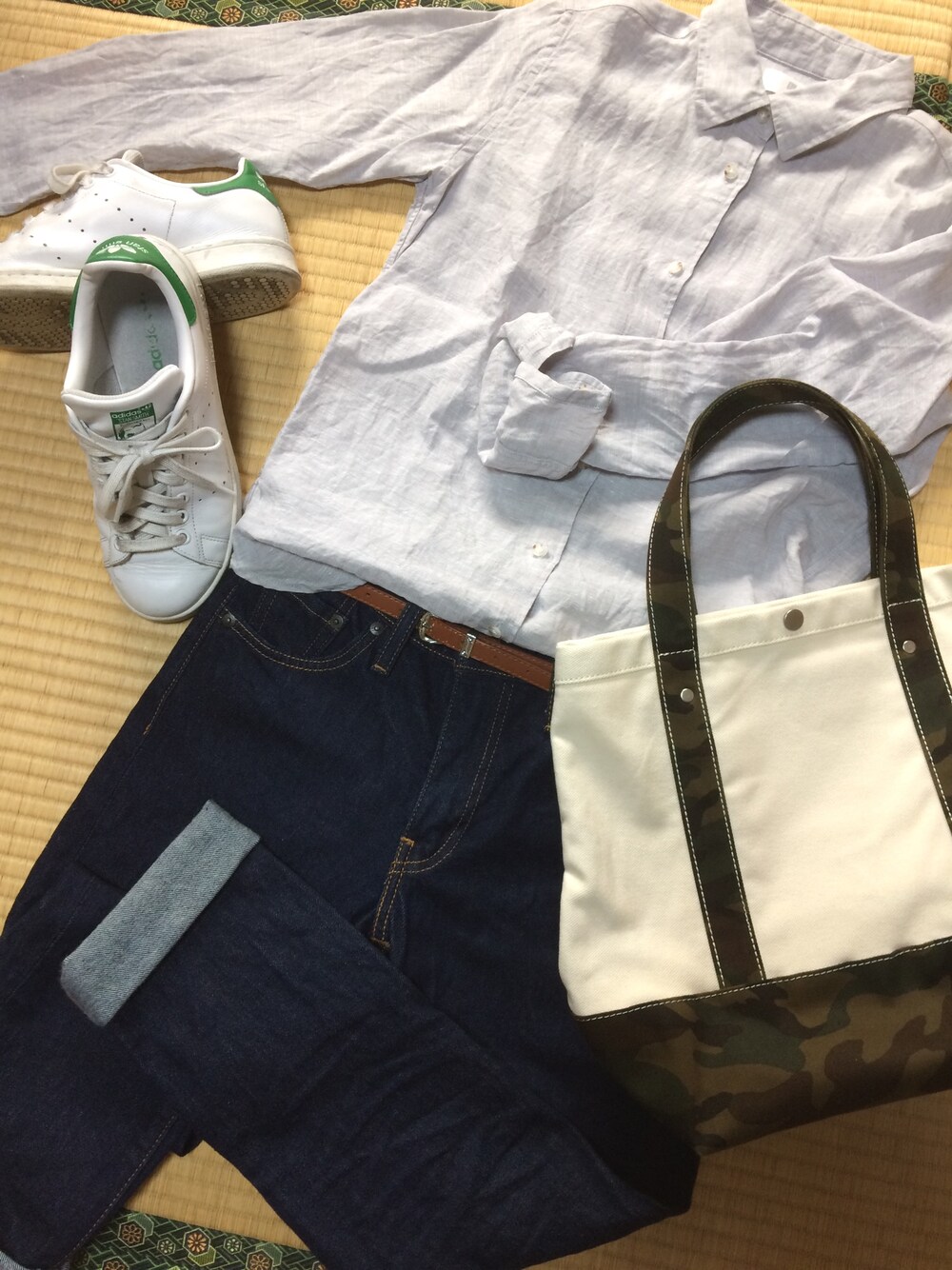 グレー系のシャツ/ブラウス、ブルー系のデニムパンツ、ホワイト系のトートバッグを着用したレディースの春コーディネートの1枚目の写真