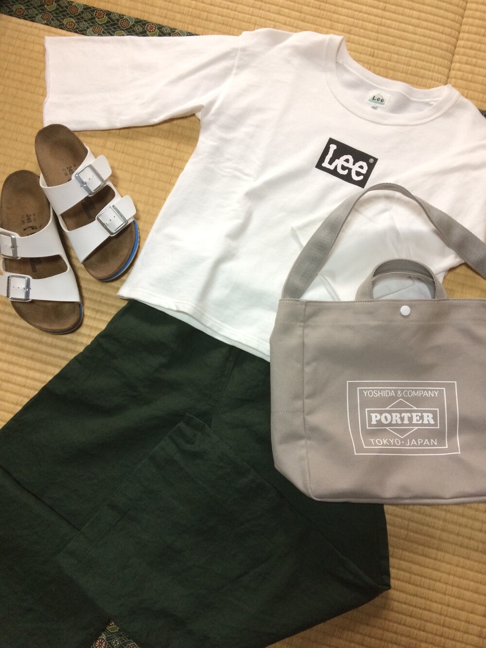 ホワイト系のTシャツ/カットソー、グリーン系のその他パンツ、グレー系のトートバッグを着用したレディースの春コーディネートの1枚目の写真