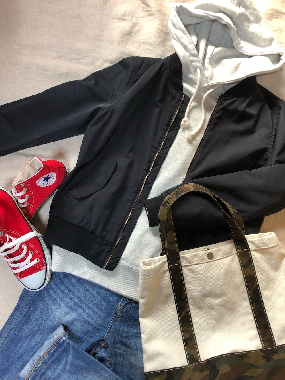 ブルー系のMA-1、ホワイト系のパーカー、ブルー系のデニムパンツを着用したレディースの春コーディネートの1枚目の写真