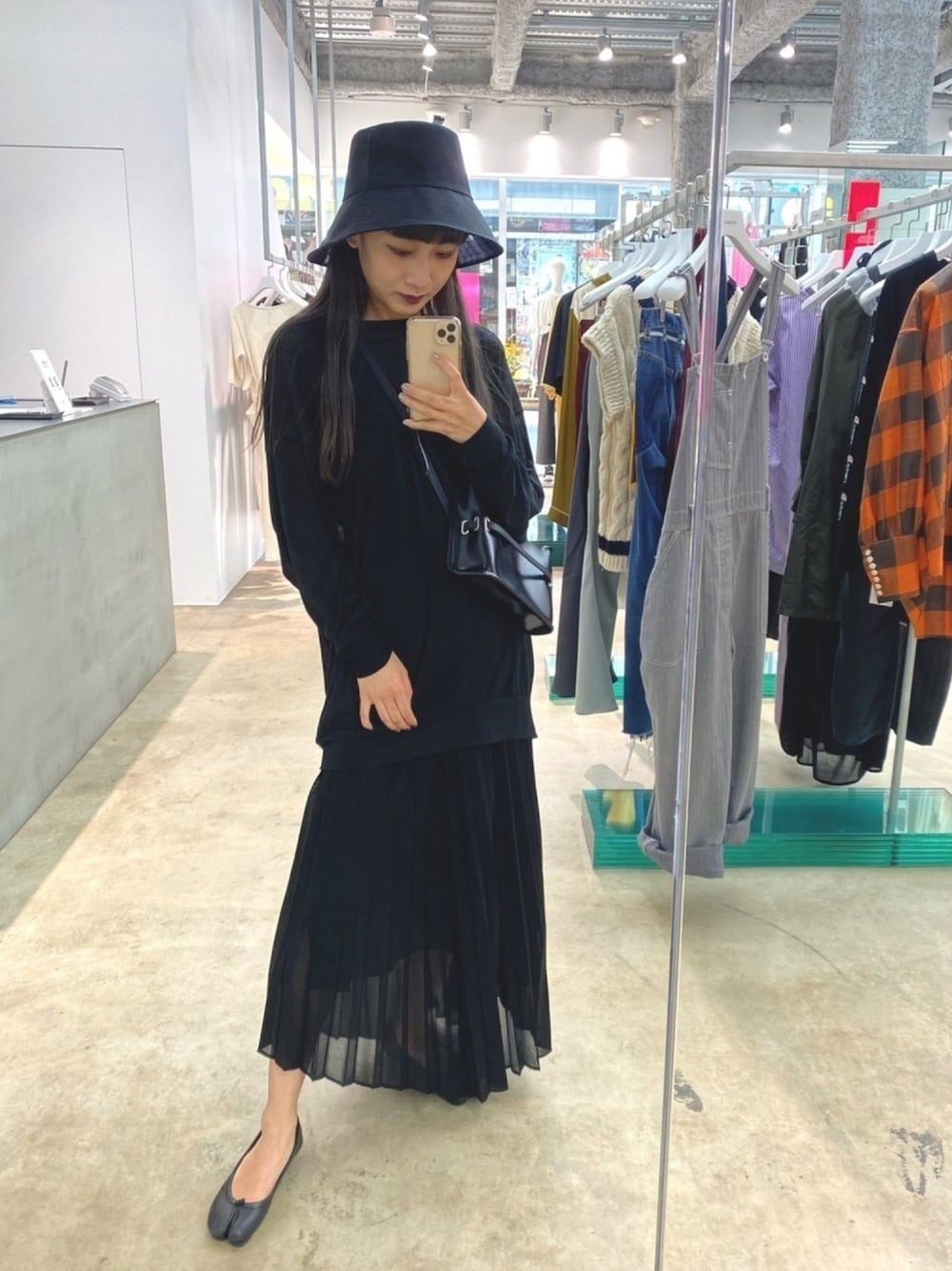 ブラック系のスカート、ブラック系の帽子を着用したレディースの夏コーディネートの1枚目の写真