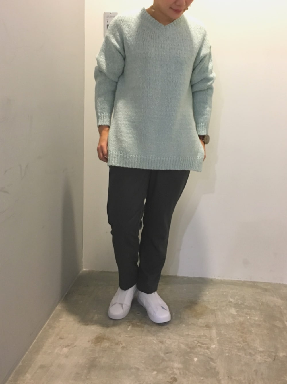グリーン系のニット/セーター、グレー系のその他パンツ、ホワイト系のスニーカーを着用したレディースの秋コーディネートの1枚目の写真