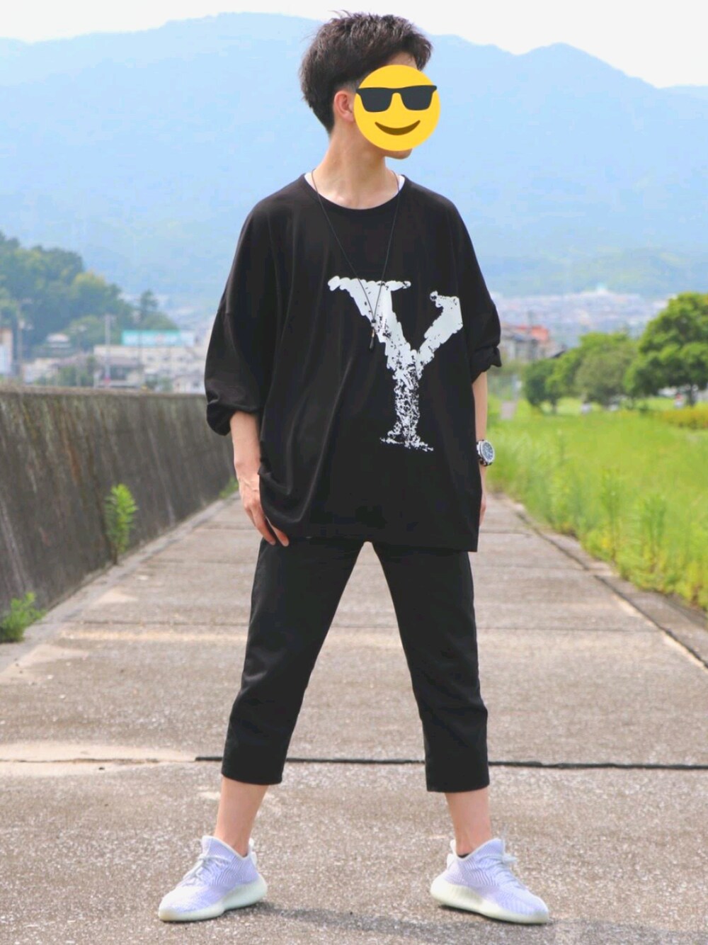 ホワイト系のスニーカー、ブラック系のチノパンツ、ブラック系のトップスを着用したメンズの夏コーディネートの1枚目の写真