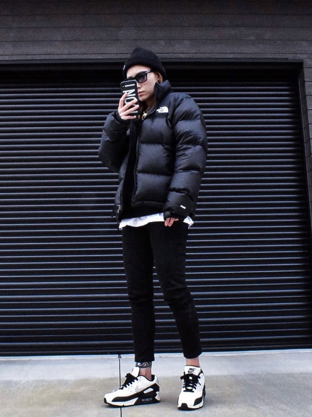 ブラック系のパーカー、ブラック系のダウンジャケット/コート、ブラック系のデニムパンツを着用したレディースの冬コーディネートの1枚目の写真