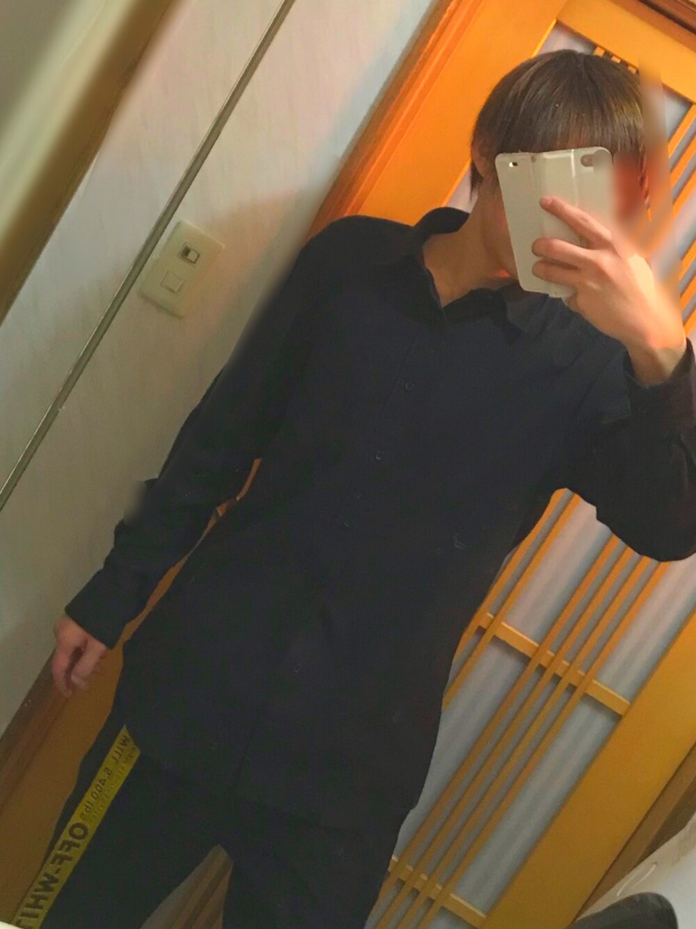 ブラック系のシャツ/ブラウス、ブラック系のチノパンツ、イエロー系のベルトを着用したメンズの冬コーディネートの1枚目の写真