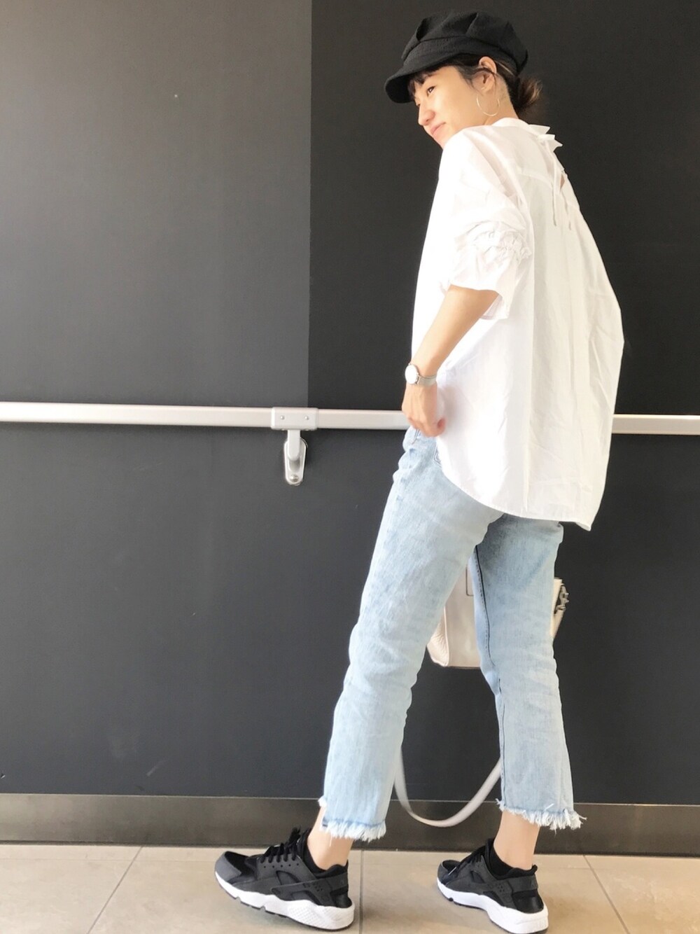 ホワイト系のシャツ/ブラウス、ブルー系のデニムパンツ、ブラック系のスニーカーを着用したレディースの春コーディネートの1枚目の写真