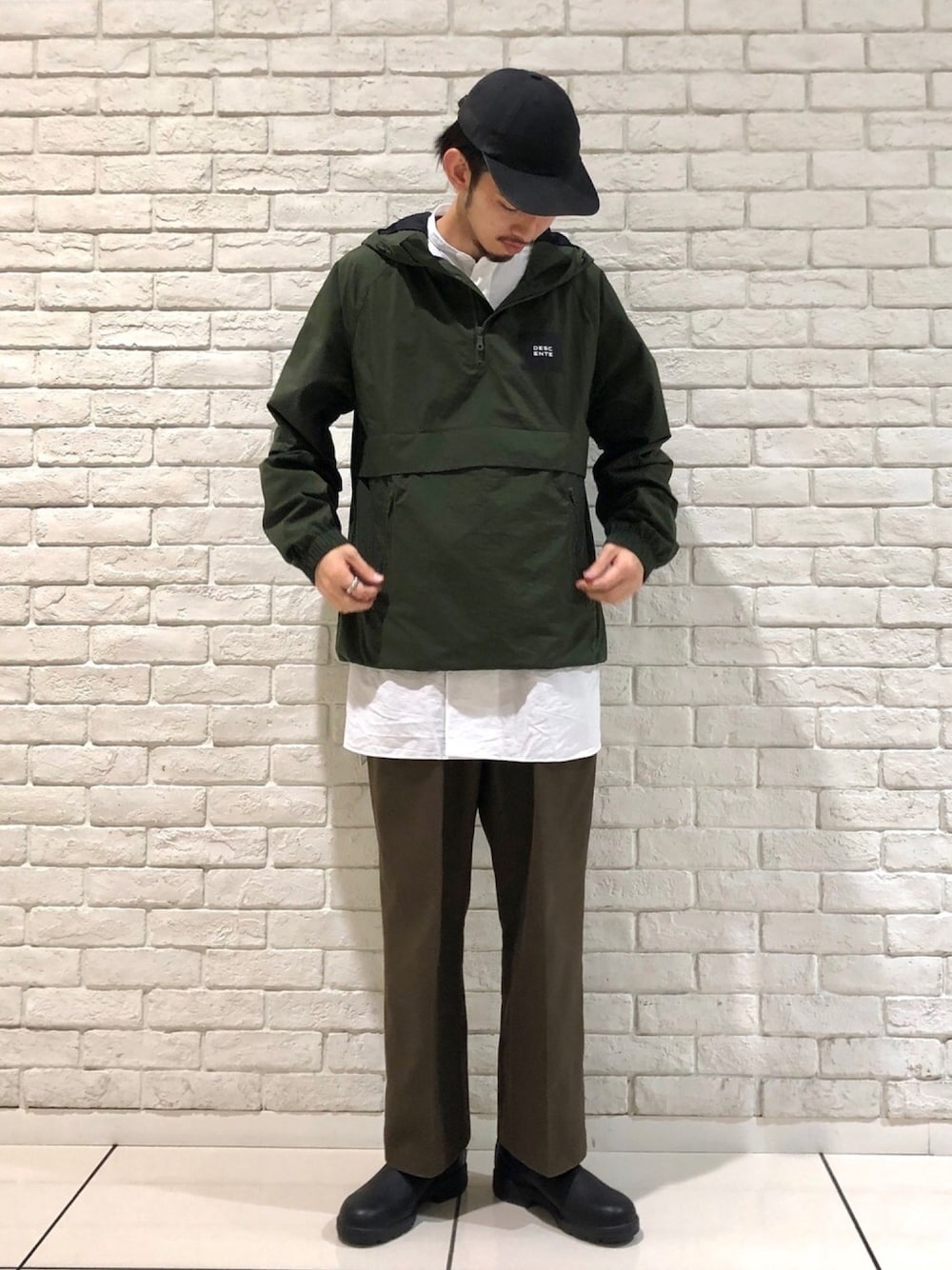 グリーン系のブルゾン、ブラック系のブーツを着用したメンズの秋コーディネートの1枚目の写真