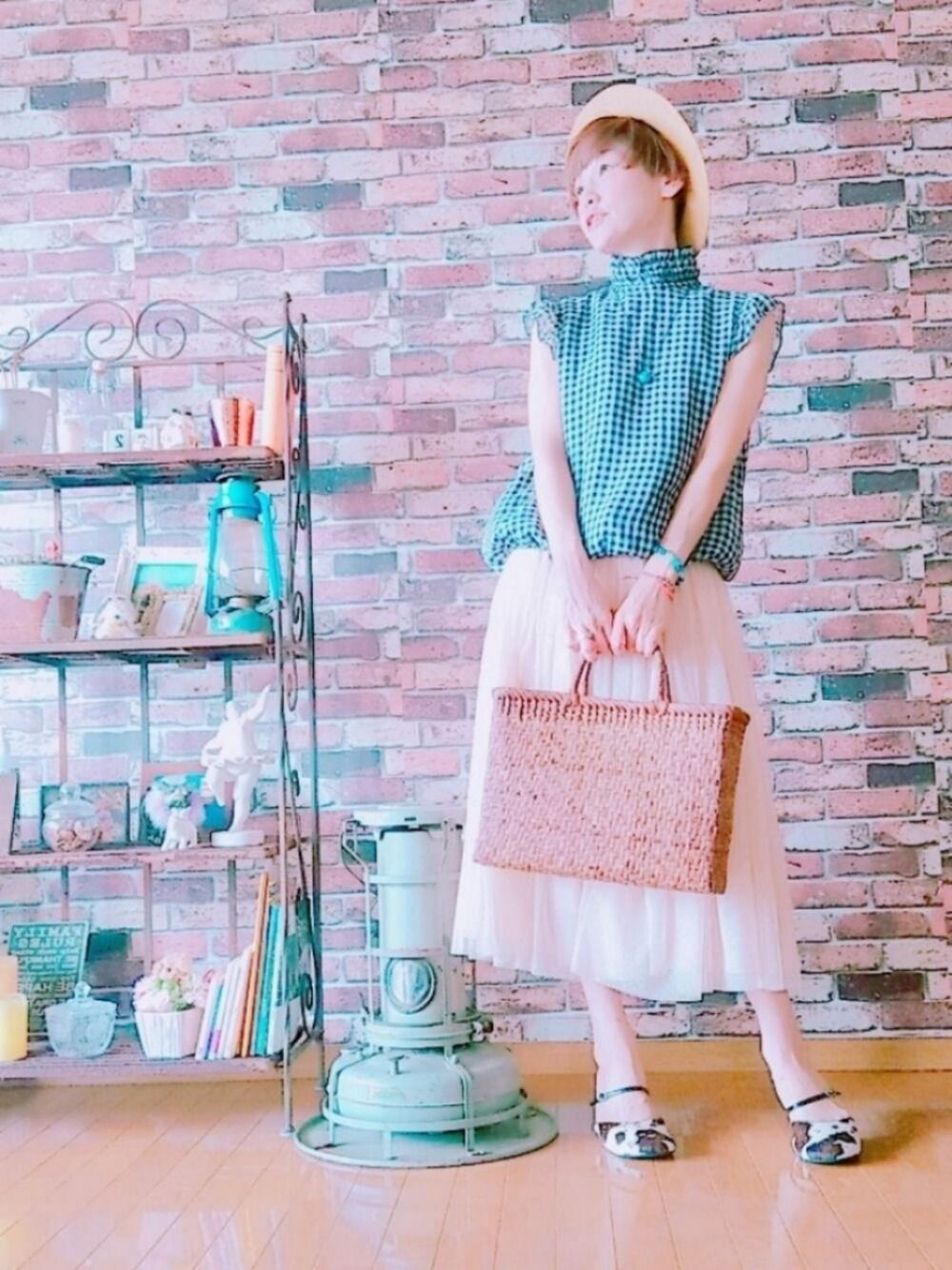 ブラウン系のトップス、ピンク系のスカート、ベージュ系のサンダルを着用したレディースの夏コーディネートの1枚目の写真