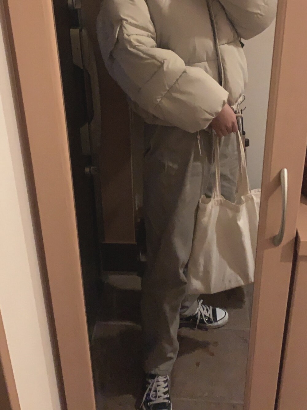 ホワイト系のダウンジャケット/コート、グリーン系のデニムパンツ、ホワイト系のトートバッグを着用したレディースの冬コーディネートの1枚目の写真