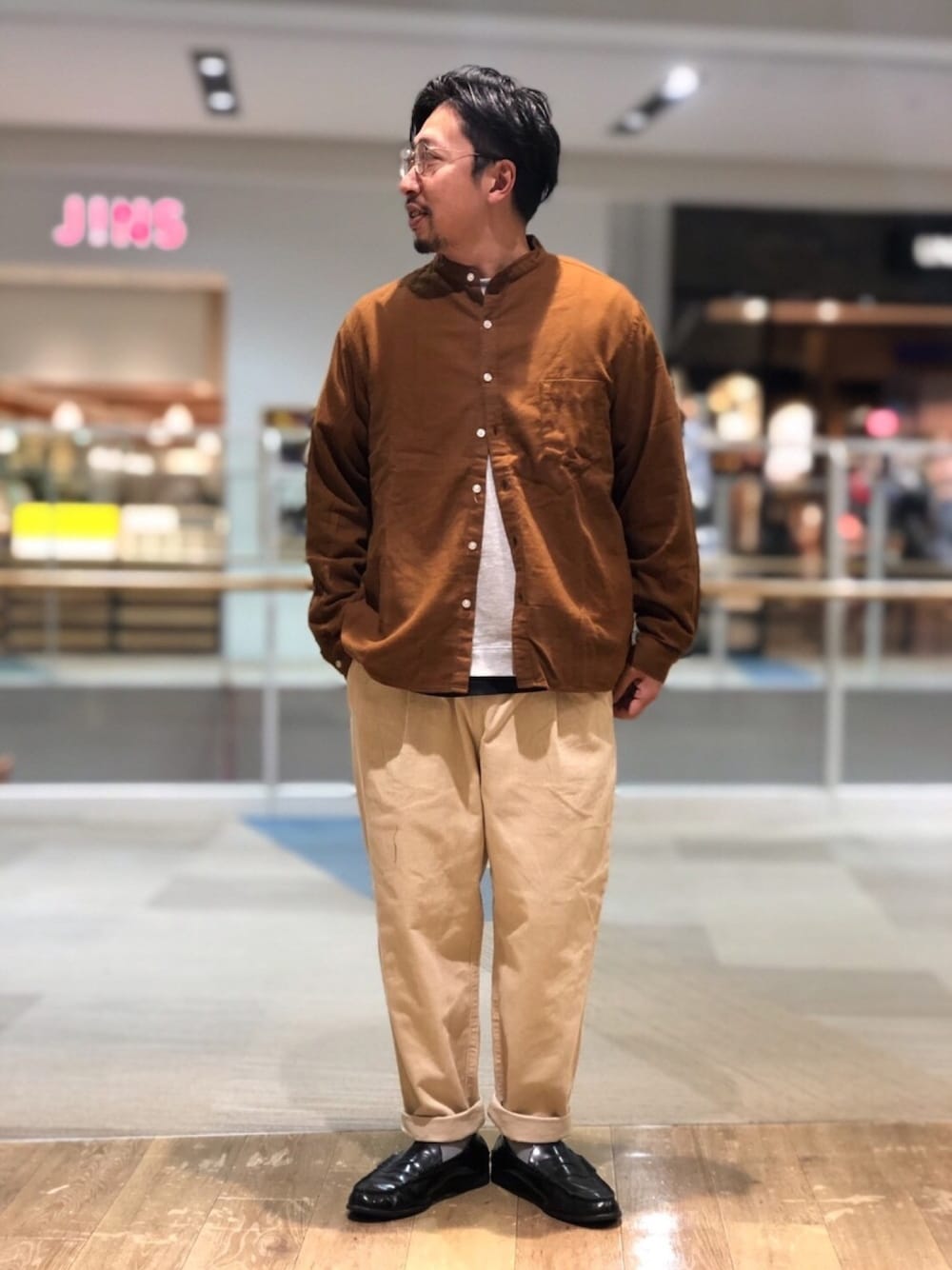 グレー系のTシャツ/カットソー、ブラウン系のシャツ/ブラウス、ホワイト系のパンツを着用したメンズの秋コーディネートの1枚目の写真