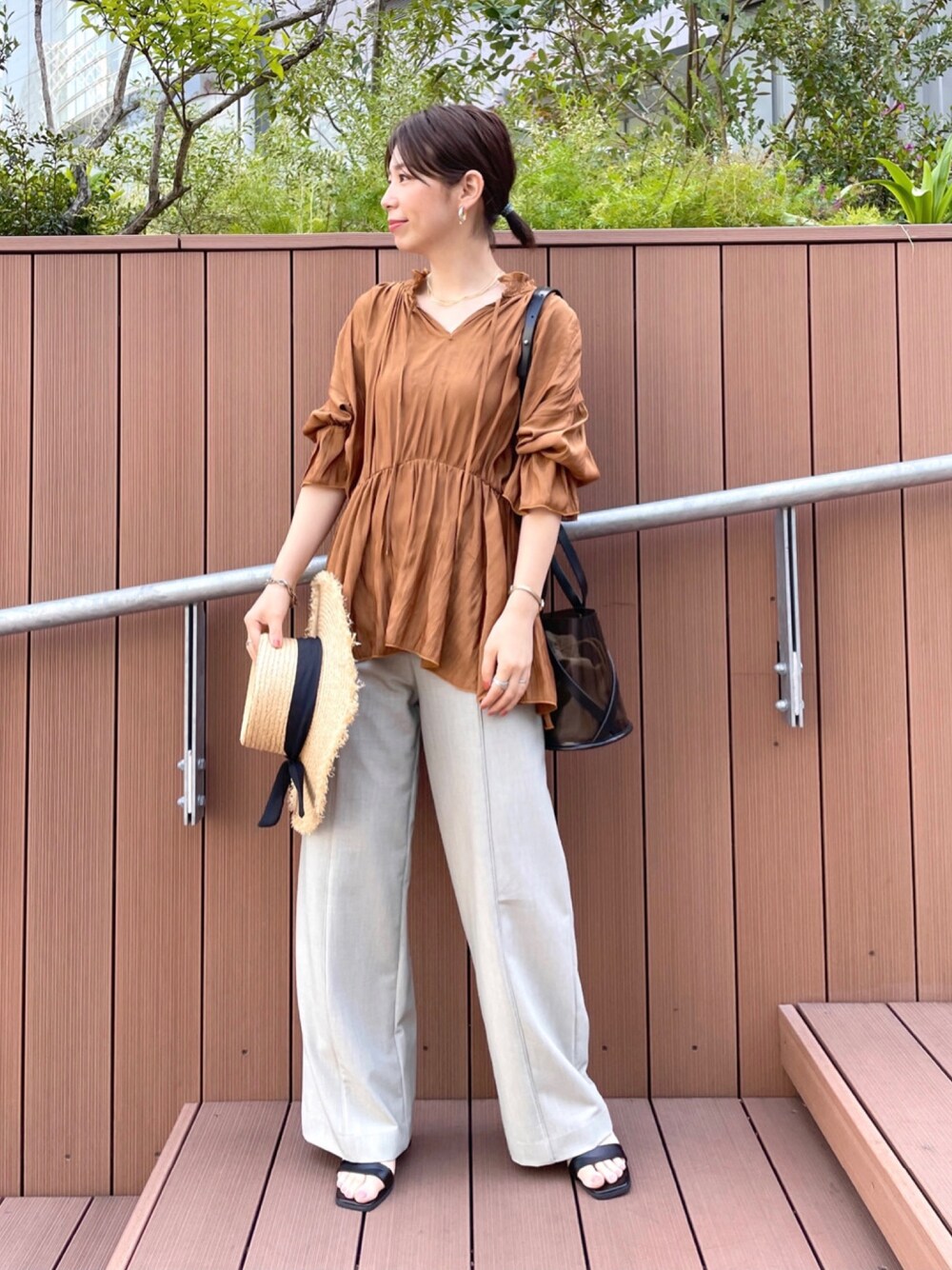 ベージュ系のシャツ/ブラウス、ベージュ系のその他パンツ、ブラック系のショルダーバッグを着用したレディースの春コーディネートの1枚目の写真