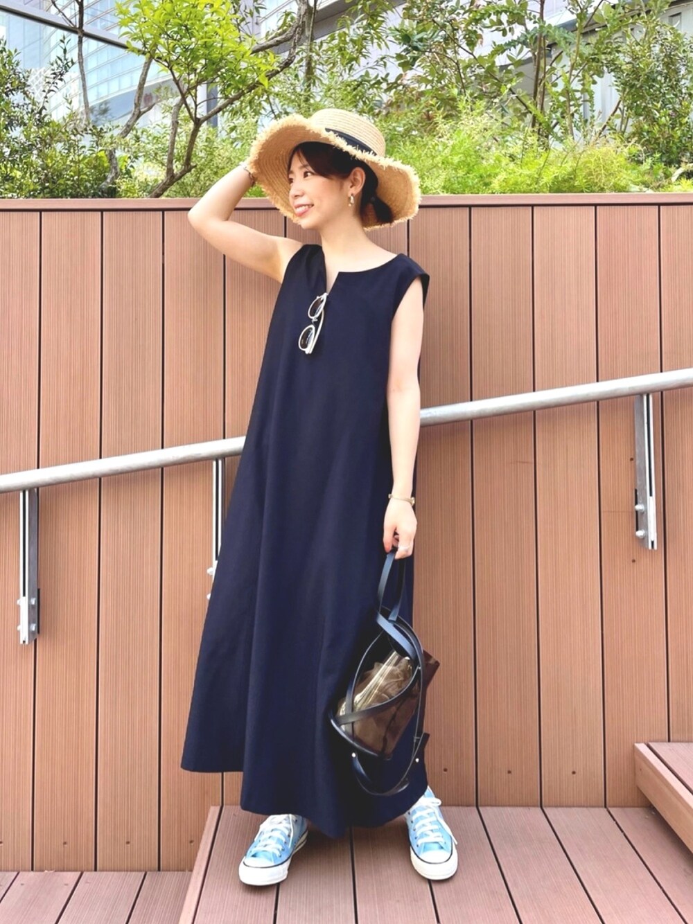 ブラック系のワンピース、ブラック系のショルダーバッグ、ブルー系のスニーカーを着用したレディースの春コーディネートの1枚目の写真