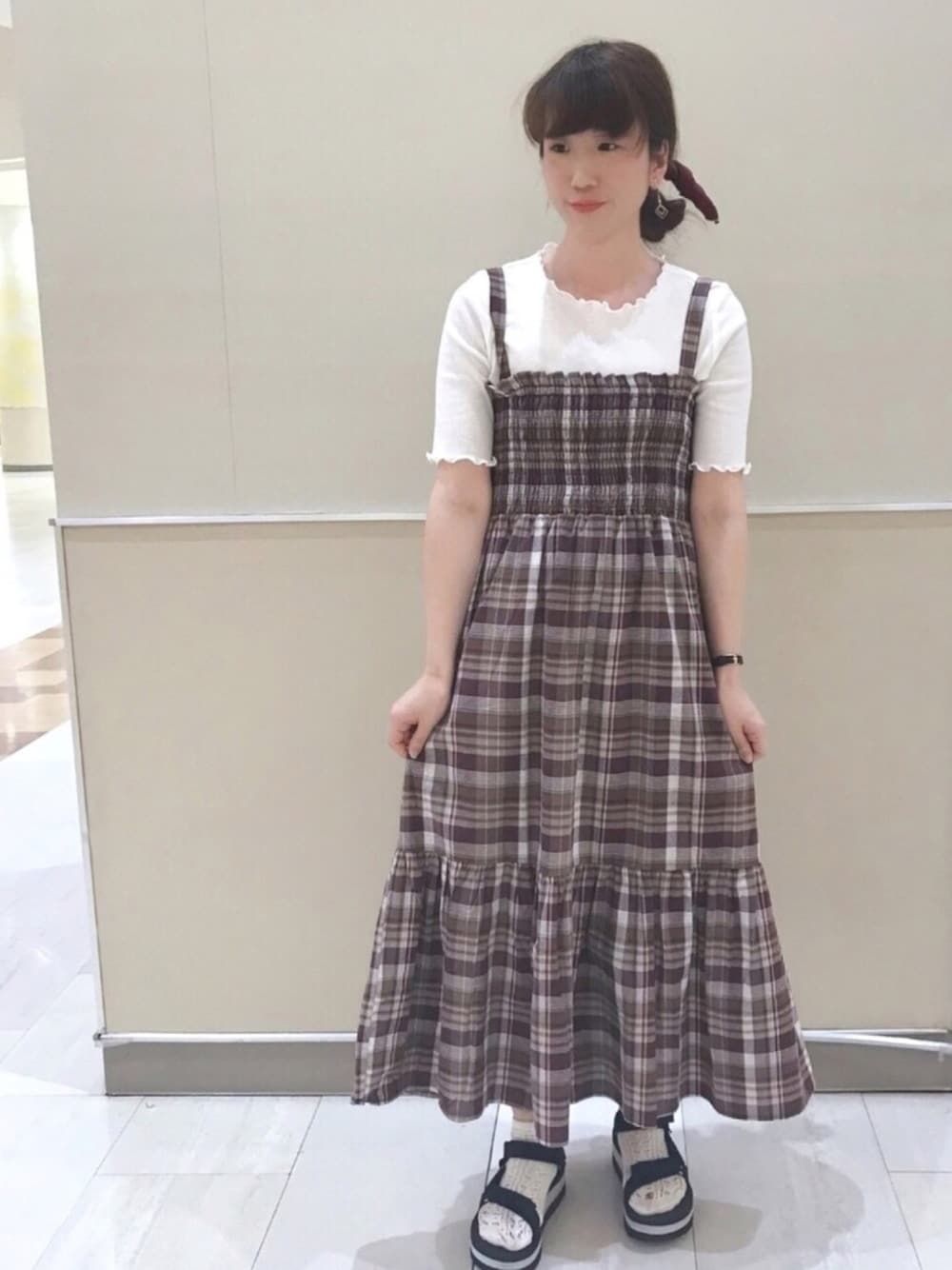 ブラック系のサンダル、ブラウン系のワンピース、ホワイト系のTシャツ/カットソーを着用したレディースの春コーディネートの1枚目の写真
