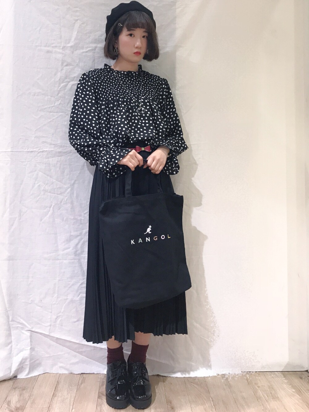 ブラック系のシャツ/ブラウス、ブラック系のスカート、ブラック系のトートバッグを着用したレディースの秋コーディネートの1枚目の写真