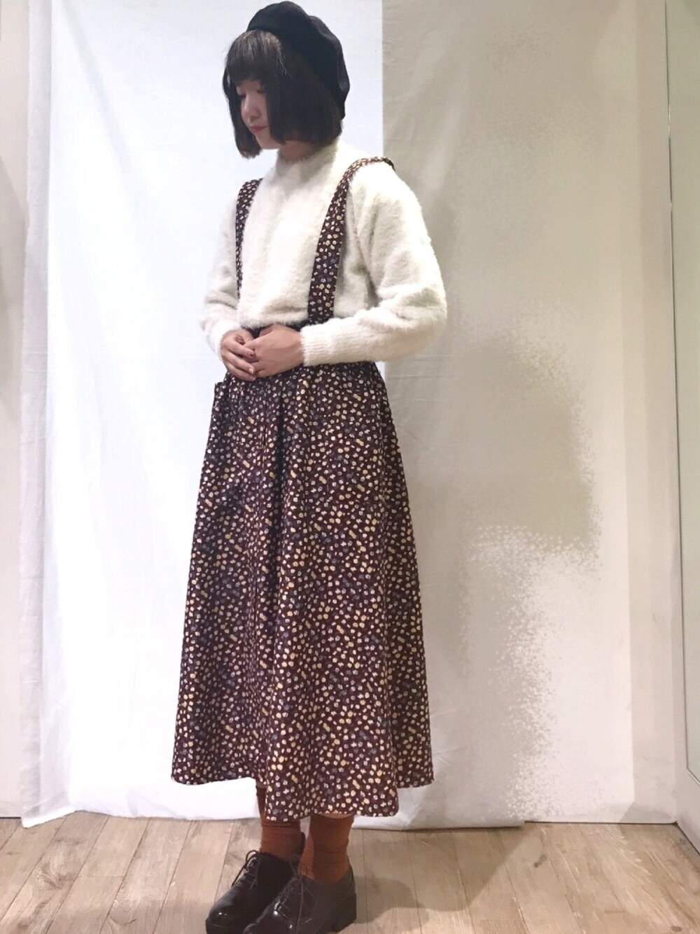 ホワイト系のニット/セーター、ブラウン系のスカート、ブラウン系のドレスシューズを着用したレディースの秋コーディネートの1枚目の写真