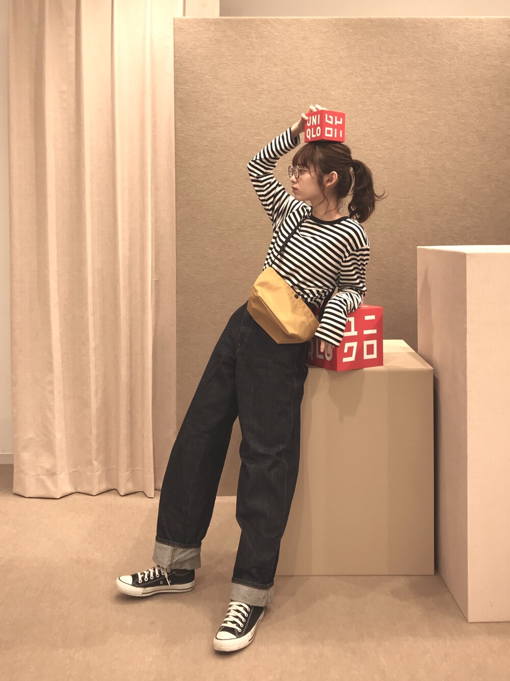 ブルー系のデニムパンツ、ブラック系のトップス、イエロー系のバッグを着用したレディースの秋コーディネートの1枚目の写真