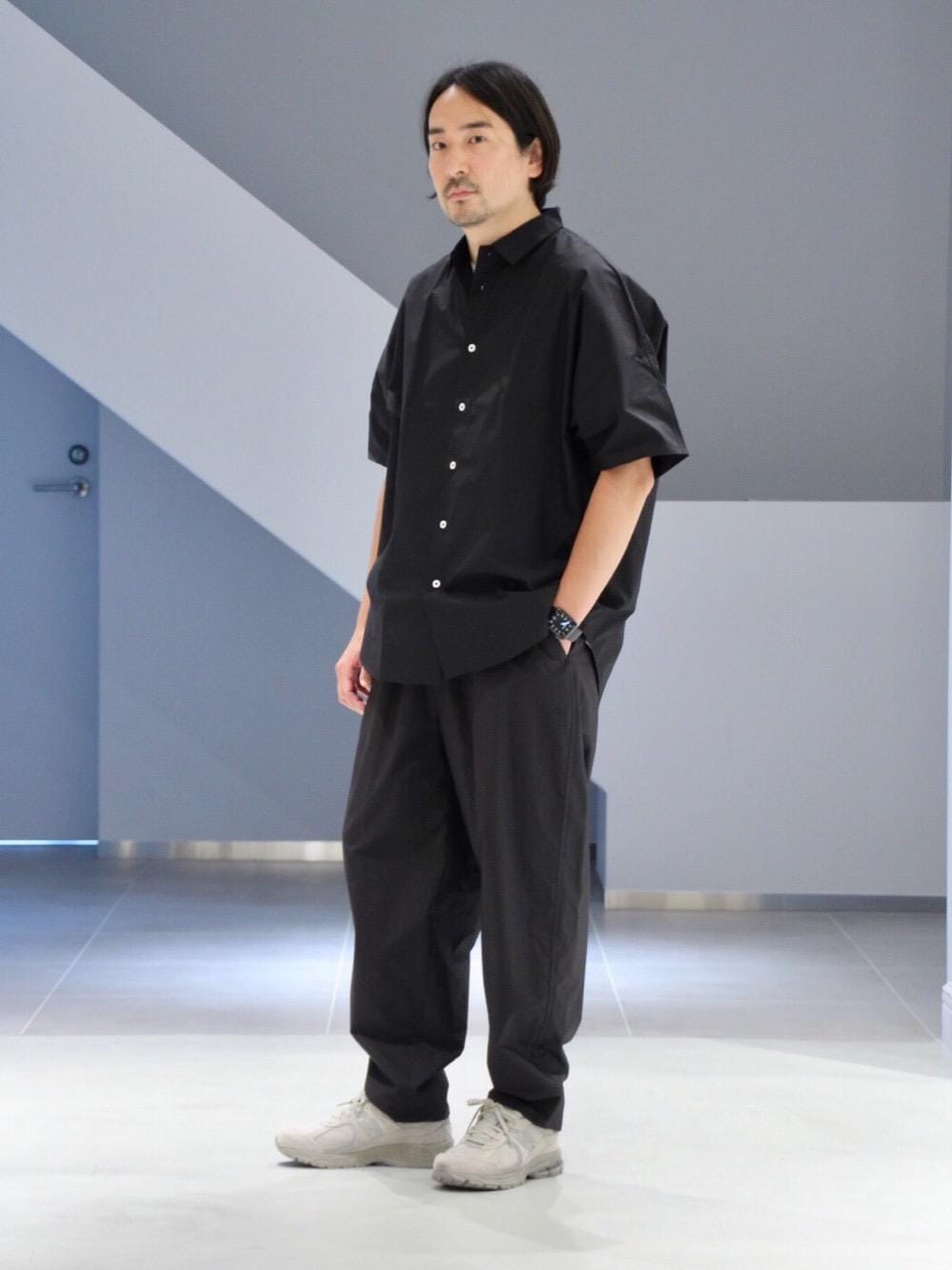 ブラック系のその他パンツ、ブラック系のシャツ/ブラウス、ベージュ系のスニーカーを着用したメンズの春コーディネートの1枚目の写真