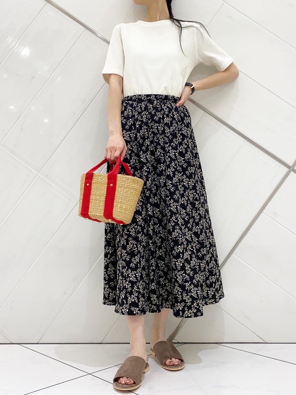 ホワイト系のTシャツ/カットソー、ブラック系のスカート、ベージュ系のかごバッグを着用したレディースの春コーディネートの1枚目の写真