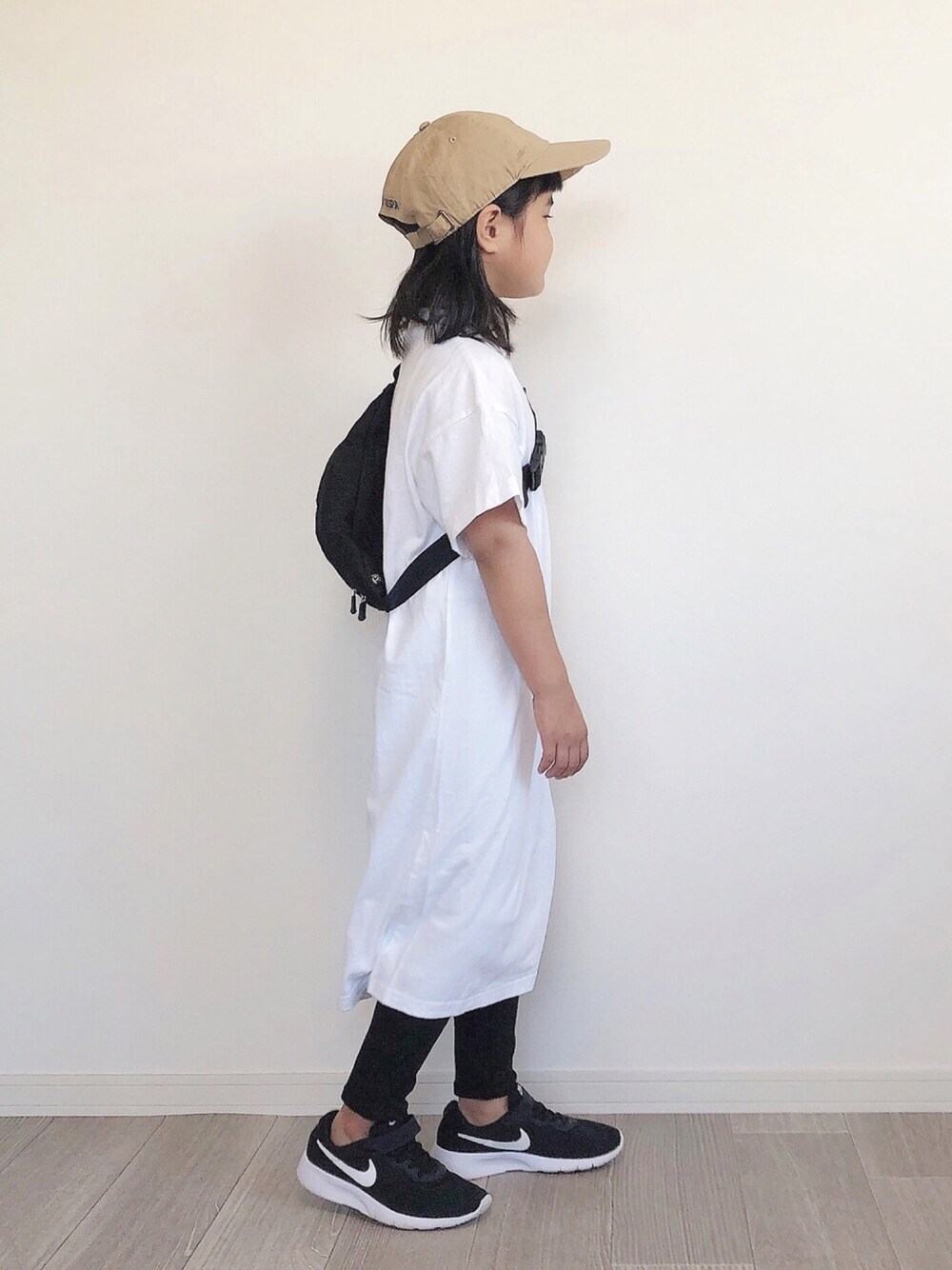 ホワイト系のワンピース、ブラック系のその他パンツ、ブラック系のボディバッグ/ウエストポーチを着用したキッズの夏コーディネートの1枚目の写真