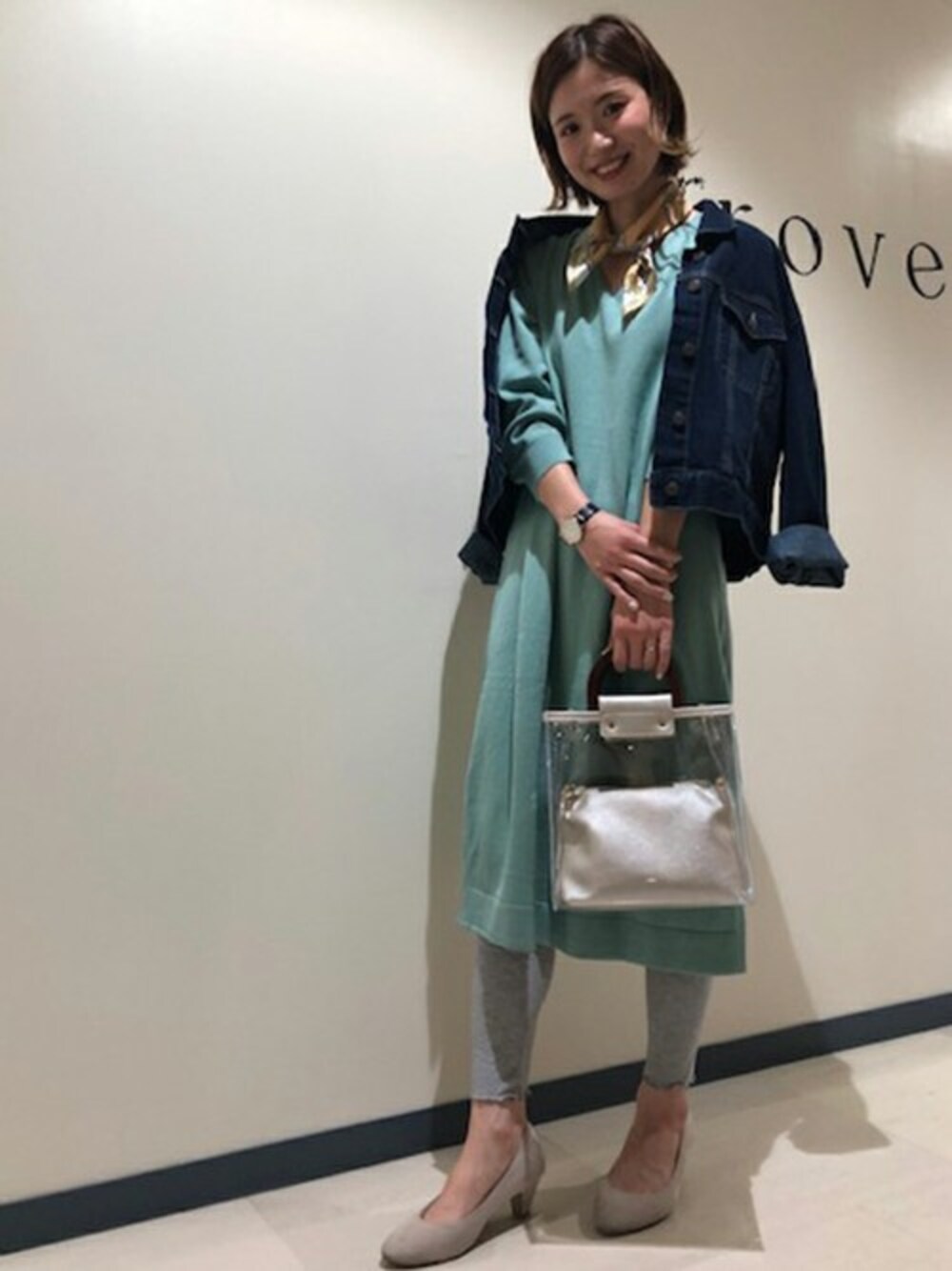 グリーン系のワンピース、ブルー系のデニムジャケット、シルバー系のトートバッグを着用したレディースの春コーディネートの1枚目の写真