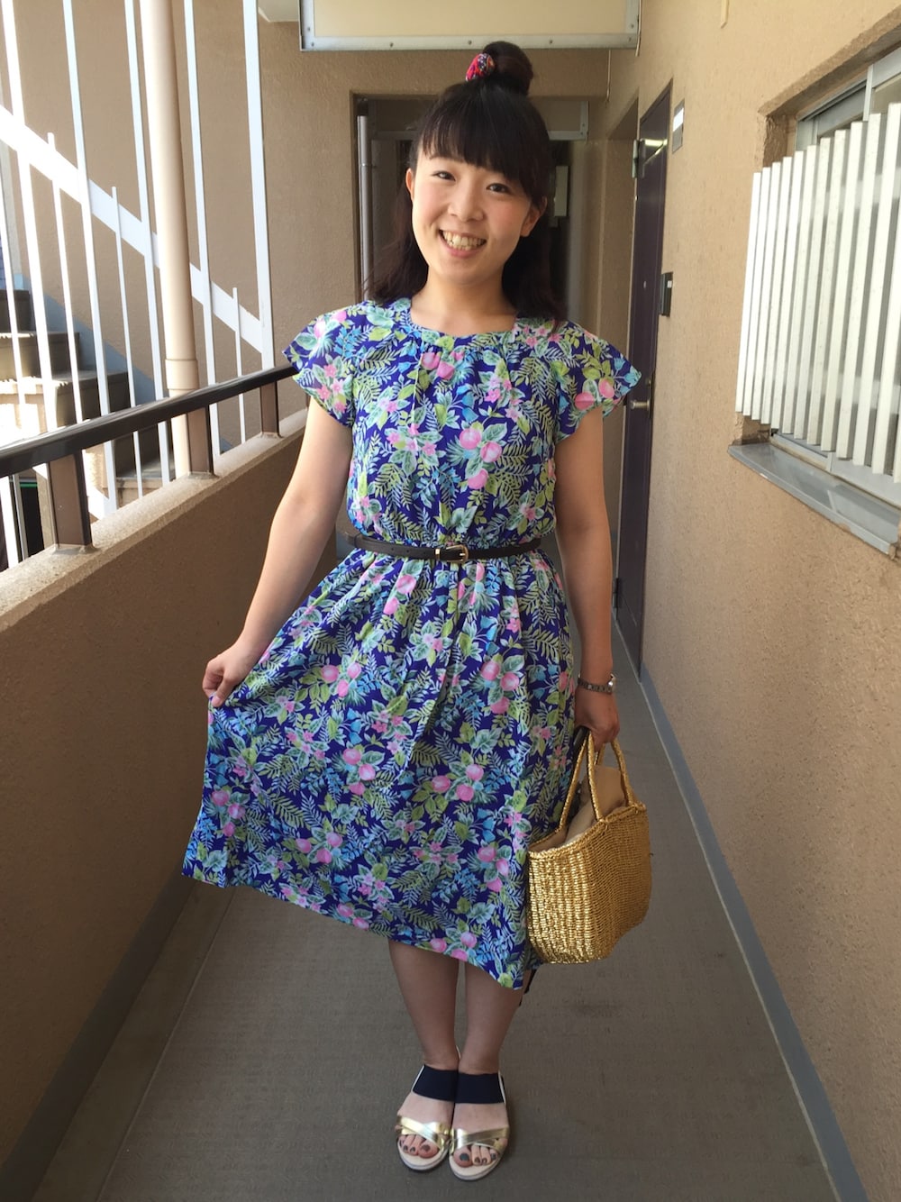 ブルー系のワンピース、ゴールド系のかごバッグ、ホワイト系のサンダルを着用したレディースの夏コーディネートの1枚目の写真