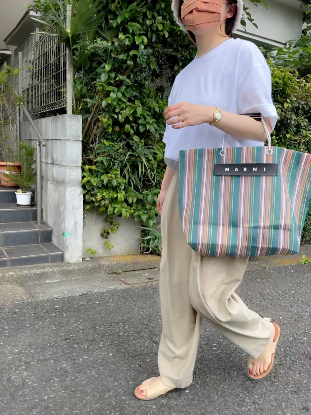 ベージュ系のその他パンツ、グリーン系のトートバッグ、ベージュ系のサンダルを着用したレディースの春コーディネートの1枚目の写真