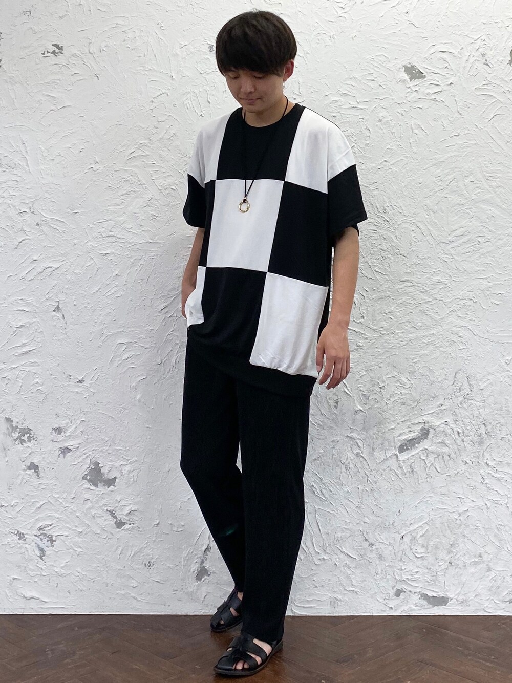 ブラック系のTシャツ/カットソー、ブラック系のチノパンツ、ゴールド系のネックレスを着用したメンズの夏コーディネートの1枚目の写真