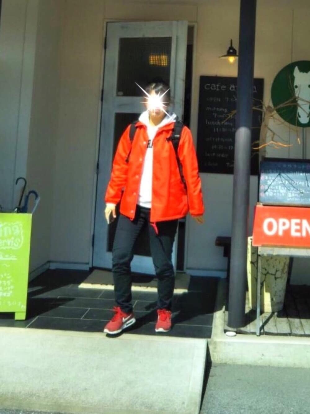 レッド系のナイロンジャケット、ホワイト系のパーカー、ブラック系のバックパック/リュックを着用したレディースの春コーディネートの1枚目の写真