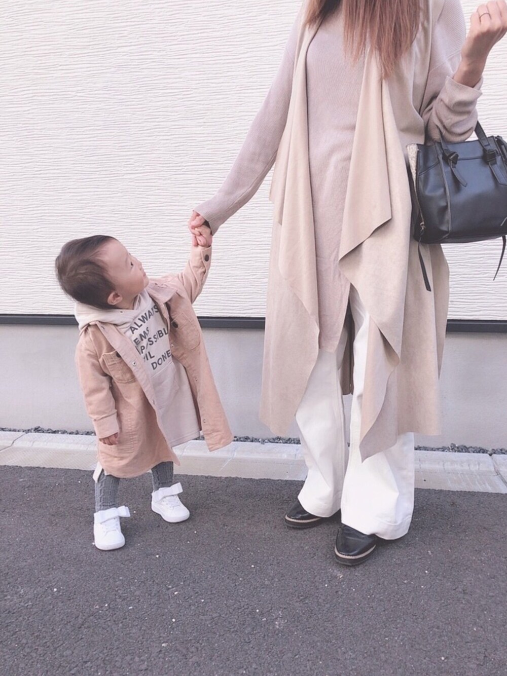 ホワイト系のスニーカー、グレー系のパンツ、ベージュ系のシャツワンピースを着用したキッズの秋コーディネートの1枚目の写真