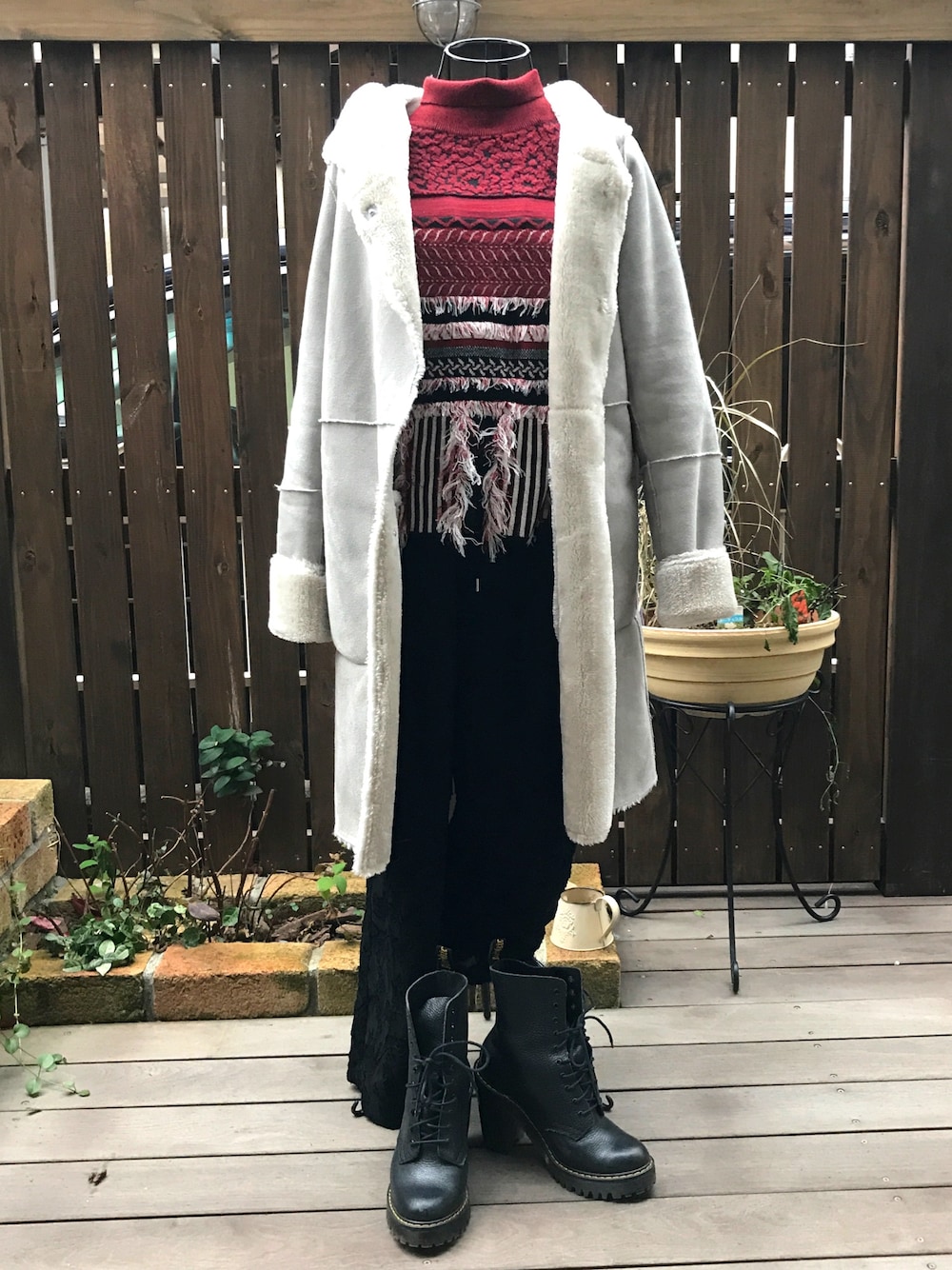 ブラック系のその他パンツ、レッド系のニット/セーター、ブラック系のブーツを着用したレディースの冬コーディネートの1枚目の写真