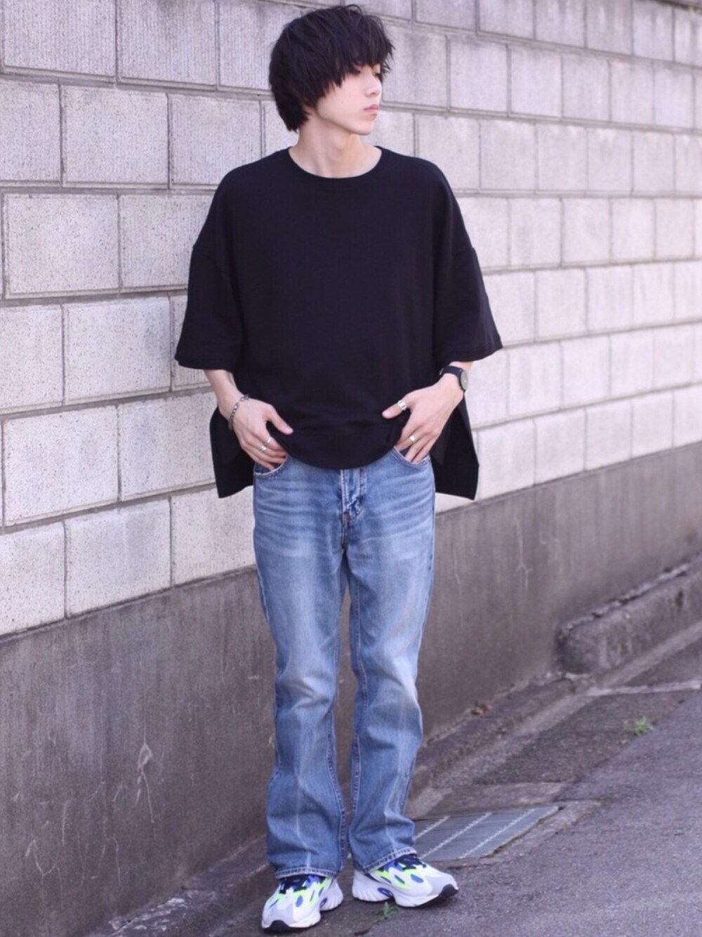 ブラック系のTシャツ/カットソー、ブルー系のデニムパンツ、ホワイト系のスニーカーを着用したメンズの秋コーディネートの1枚目の写真