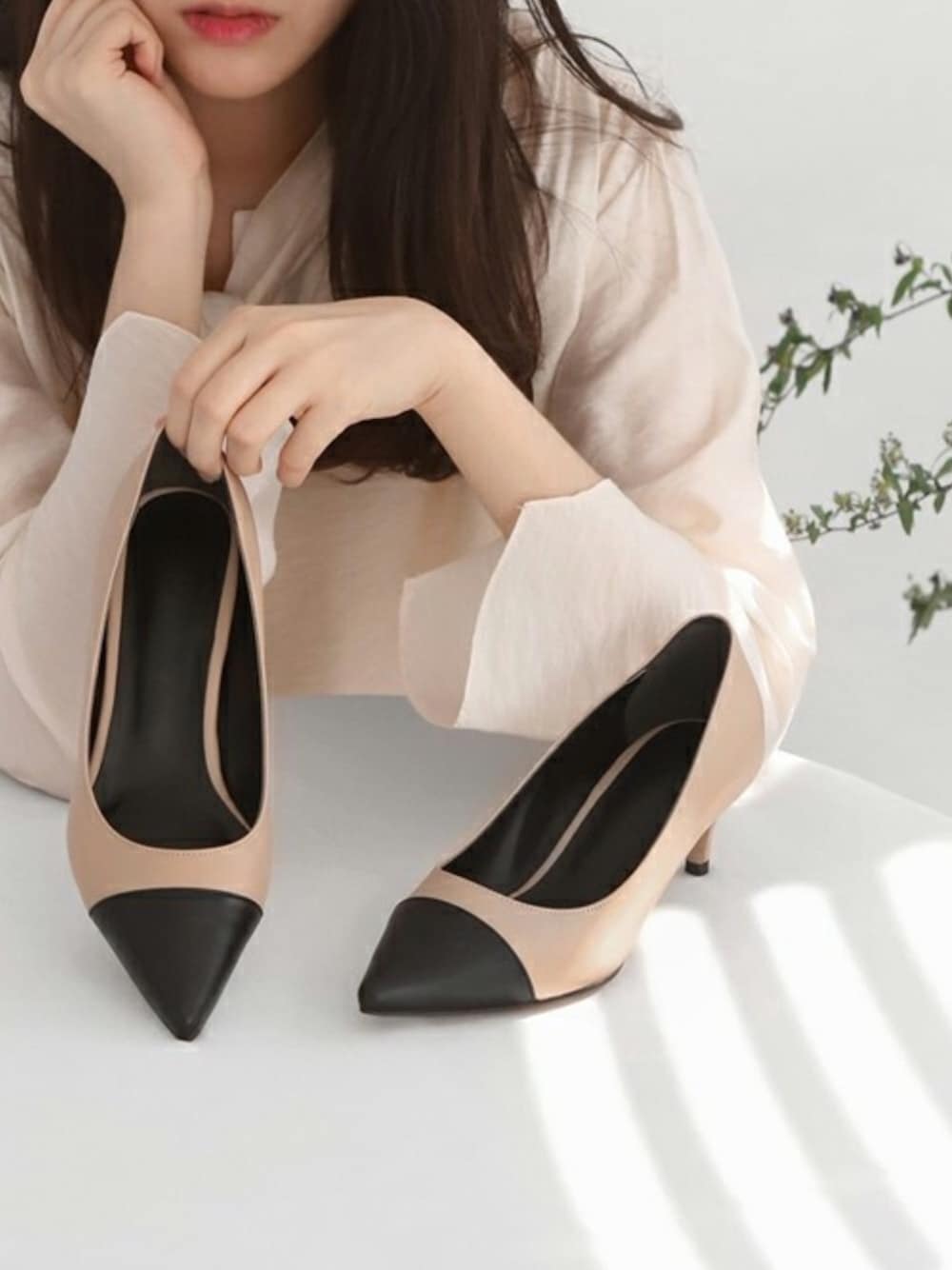 ベージュ系のパンプス、ブラック系のパンプスを着用したレディースの春コーディネートの1枚目の写真