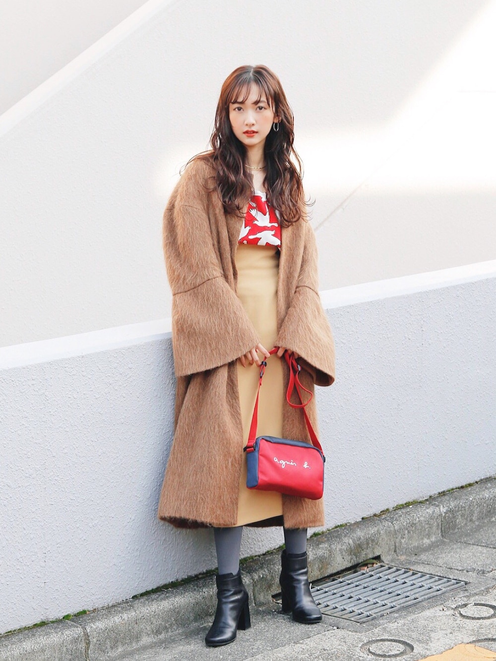 レッド系のショルダーバッグを着用したレディースの冬コーディネートの1枚目の写真