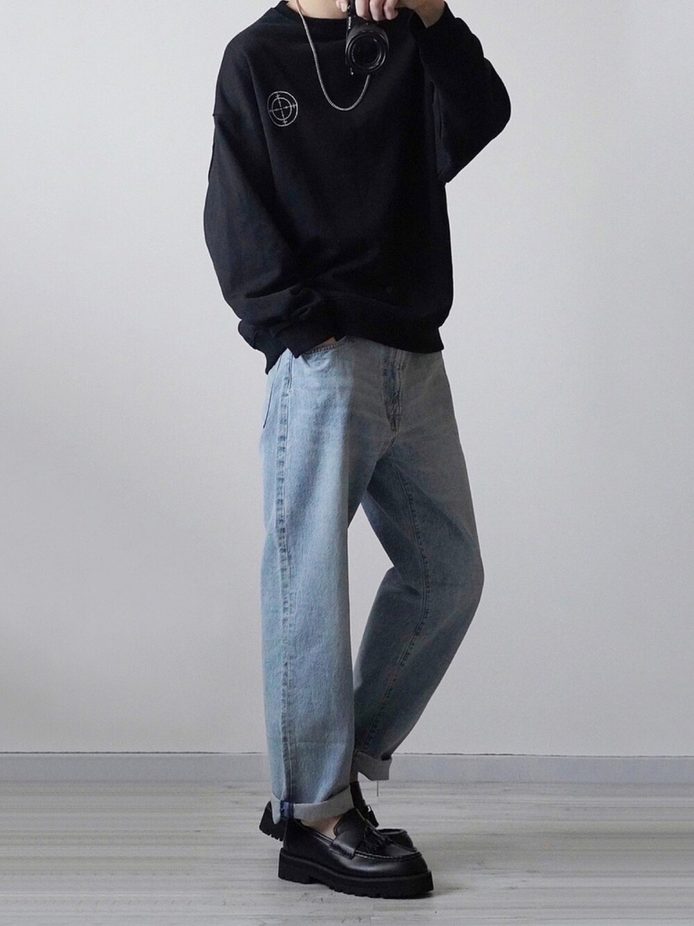 ブラック系のスウェット、ブルー系のデニムパンツ、ブラック系のローファーを着用したメンズの冬コーディネートの1枚目の写真